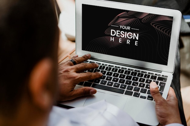 Un hombre de negocios usando una maqueta de pantalla de portátil