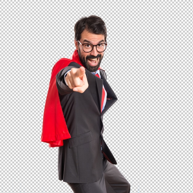 Hombre de negocios vestido como superhéroe apuntando al frente.