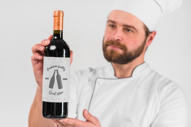 Hombre presentando botella de vino
