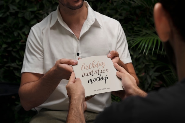 PSD hombre que recibe maqueta de invitación de cumpleaños