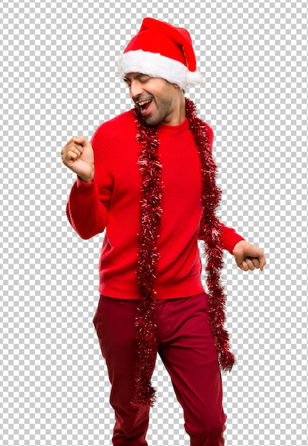 Un hombre con ropa roja que celebra las vacaciones de navidad disfruta de bailar mientras escucha m