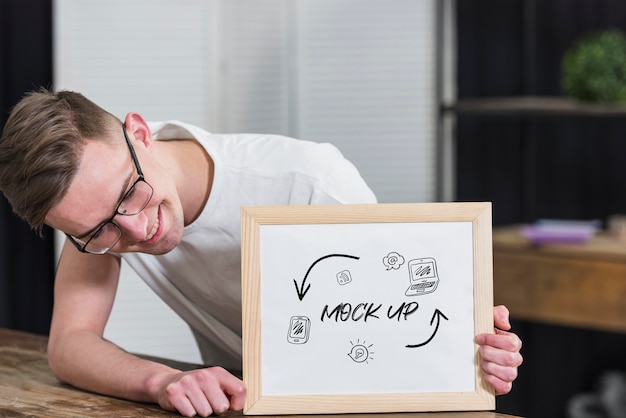 Hombre sonriente con gafas con marco de maqueta