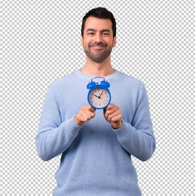 Hombre con suéter azul con reloj despertador vintage