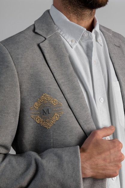 Hombre vestido con elegante blazer gris con emblema bordado