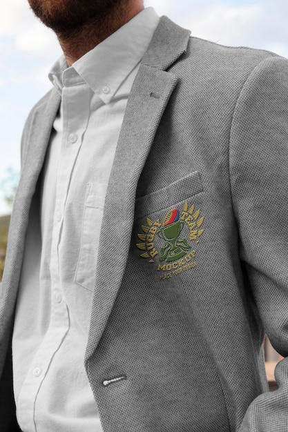 Hombre vestido con elegante blazer gris con emblema bordado