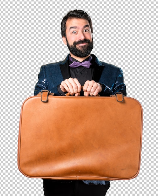 Homem bonito com casaco de lantejoulas segurando uma mala vintage