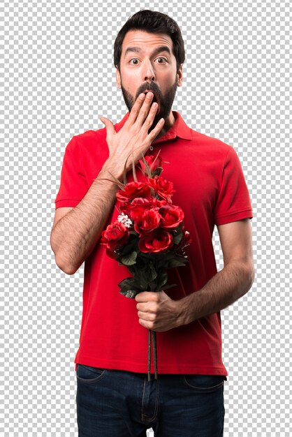 Homem bonito segurando flores fazendo gesto de surpresa