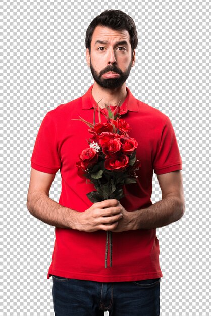 Homem bonito triste segurando flores