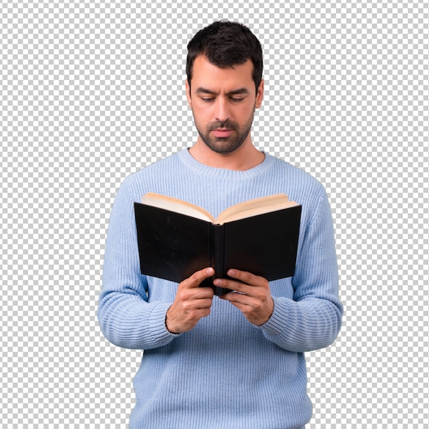 Homem com camisola azul, segurando e lendo um livro