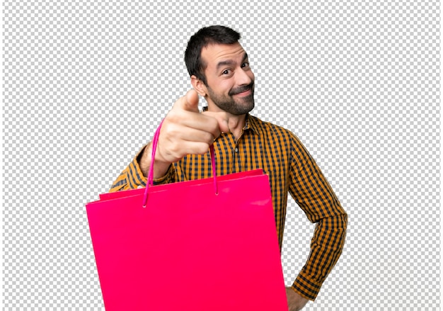 Homem com sacos de compras aponta o dedo para você com uma expressão confiante