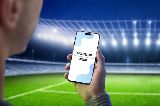 Homem com uma maquete de telefone inteligente no estádio de futebol
