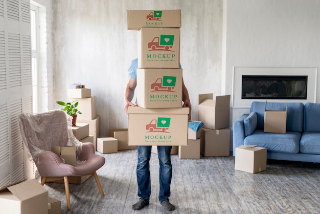 Homem segurando caixas com objetos dentro de casa