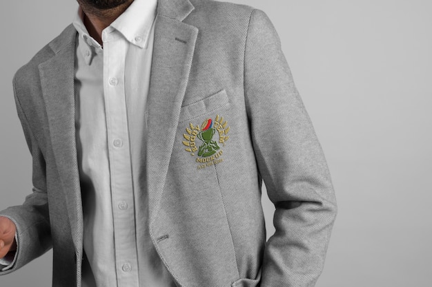 Homem vestindo elegante blazer cinza com emblema bordado