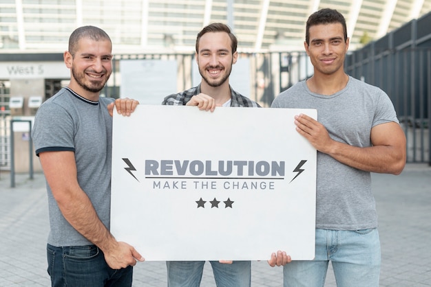 Homens segurando maquete de protesto