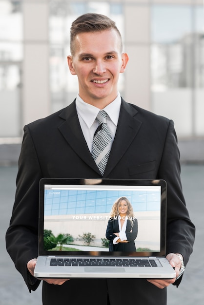 PSD homme d'affaires présentant une maquette d'ordinateur portable