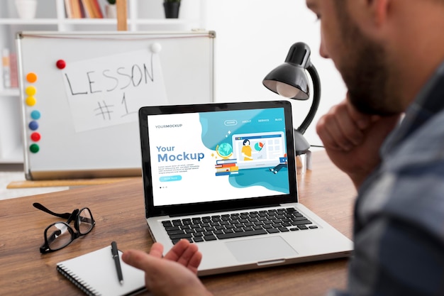 PSD homme au bureau avec maquette d'ordinateur portable