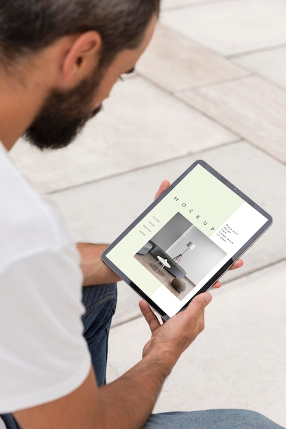 Homme dans la rue avec tablette lecture en ligne