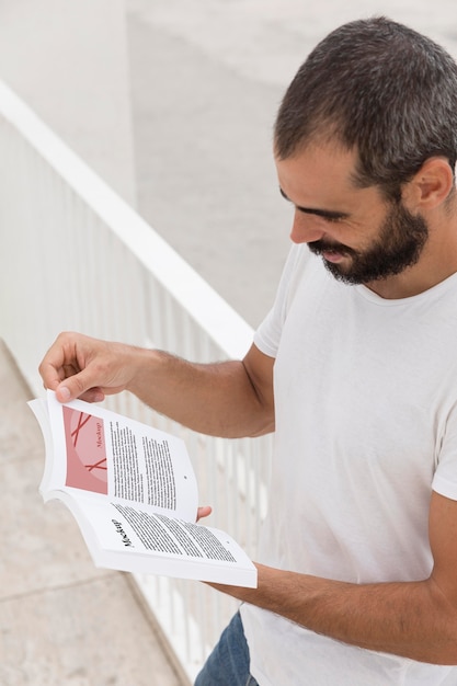 Homme sur livre de lecture de rue