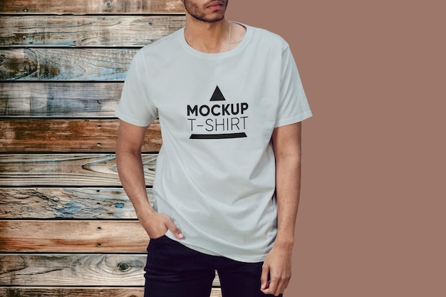 Un homme portant une maquette de T-shirt sur un fond en bois