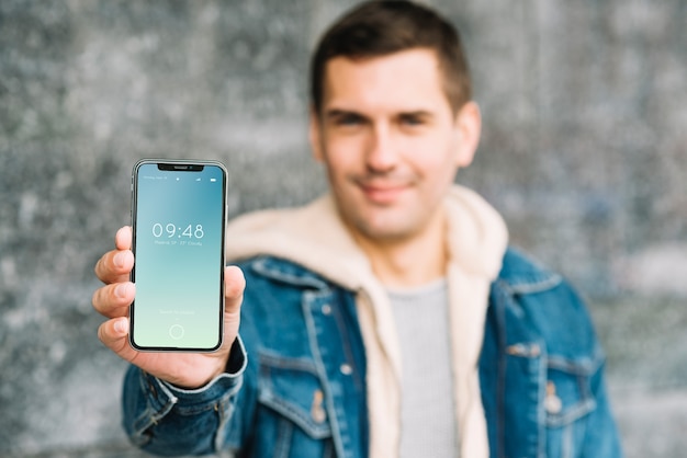 Homme présentant une maquette de smartphone