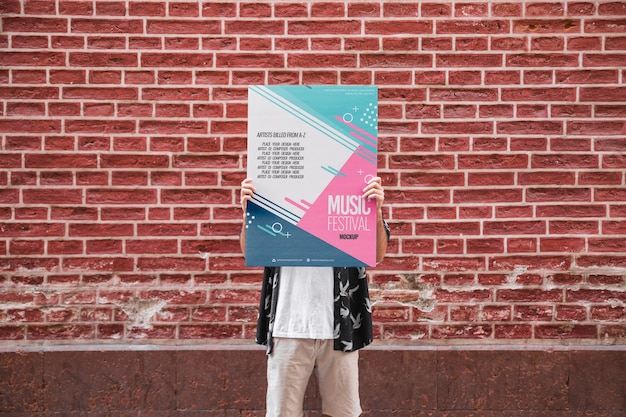 Homme, présentation, maquette affiche, devant, mur brique