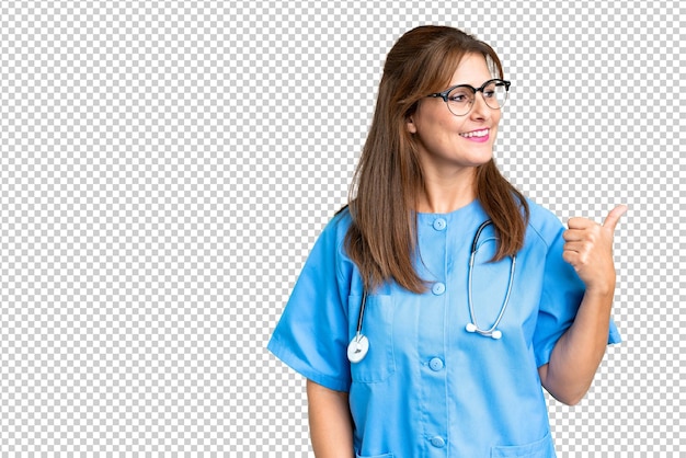 PSD infirmière d'âge moyen sur un fond isolé pointant vers le côté pour présenter un produit