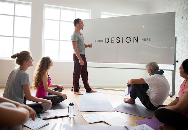 Istruttore di yoga che usa un modello di tavola per le istruzioni in classe