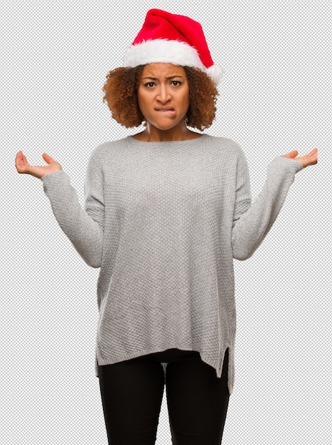 PSD jeune femme noire coiffée d'un bonnet de noel confuse et douteuse