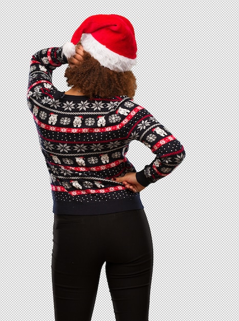 PSD jeune femme noire dans un pull de noël à la mode avec une impression par derrière de penser à quelque chose