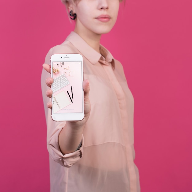 Une jeune femme tenant une maquette de smartphone