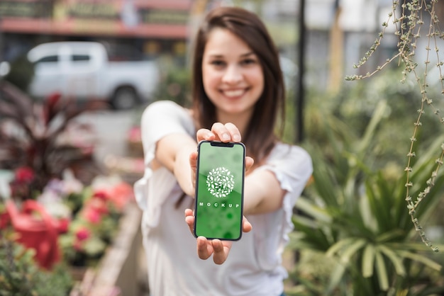 Jeune Fille Tenant Une Maquette De Smartphone Avec Concept De Jardinage