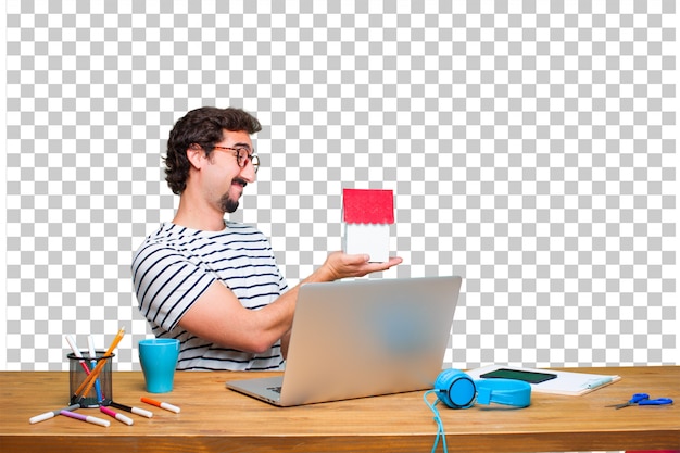 PSD jeune graphiste fou sur un bureau avec un ordinateur portable et un modèle de maison