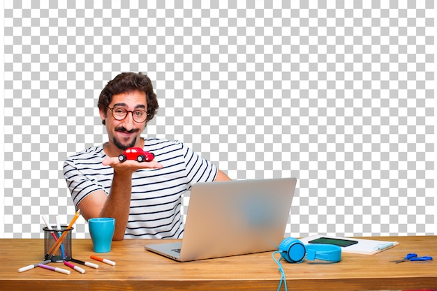 PSD jeune graphiste fou sur un bureau avec un ordinateur portable et un modèle de voiture rouge