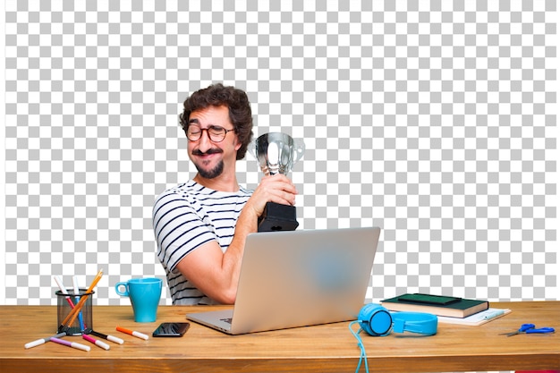 Jeune graphiste fou sur un bureau avec un ordinateur portable et