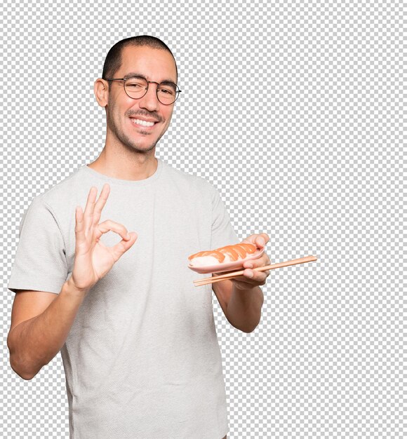 Jeune Homme à L'aide De Baguettes Pour Manger Des Sushis