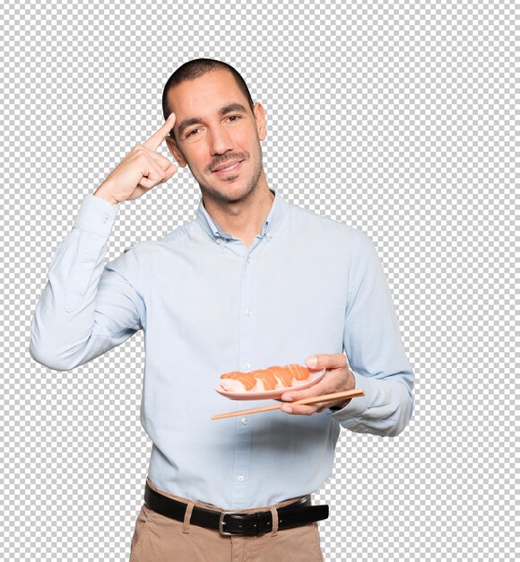 Jeune Homme à L'aide De Baguettes Pour Manger Des Sushis