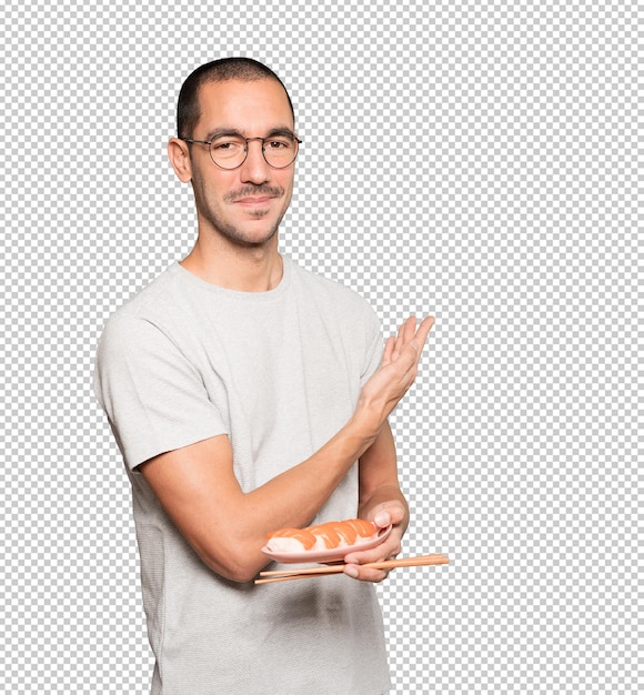 Jeune Homme à L'aide De Baguettes Pour Manger Des Sushis