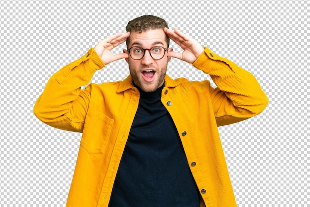 Jeune homme blond et beau sur un fond de clé chrome isolé avec une expression de surprise