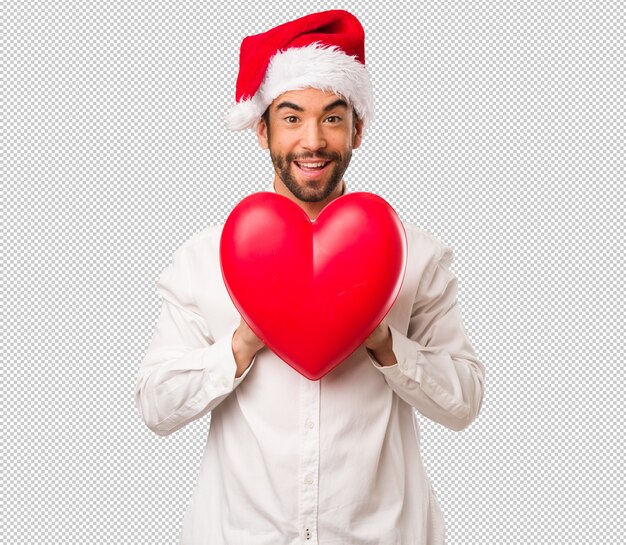 Jeune homme coiffé d&#39;un chapeau de père Noël le jour de Noël