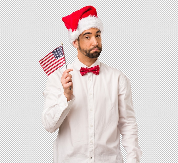 Jeune homme coiffé d&#39;un chapeau de père Noël le jour de Noël