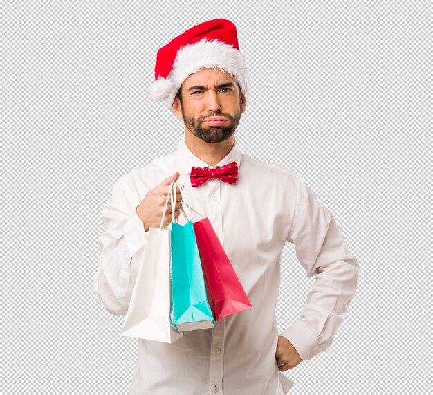 Jeune homme coiffé d&#39;un chapeau de père Noël le jour de Noël