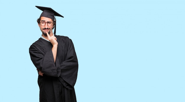 jeune homme diplômé Avec un regard confus et réfléchi, regardant de côté