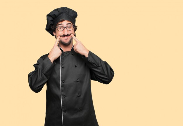 Jeune Homme Fou Comme Un Chef Forçant Un Sourire Sur Le Visage