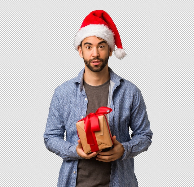 Jeune homme portant le bonnet de Noel montrant le numéro sept