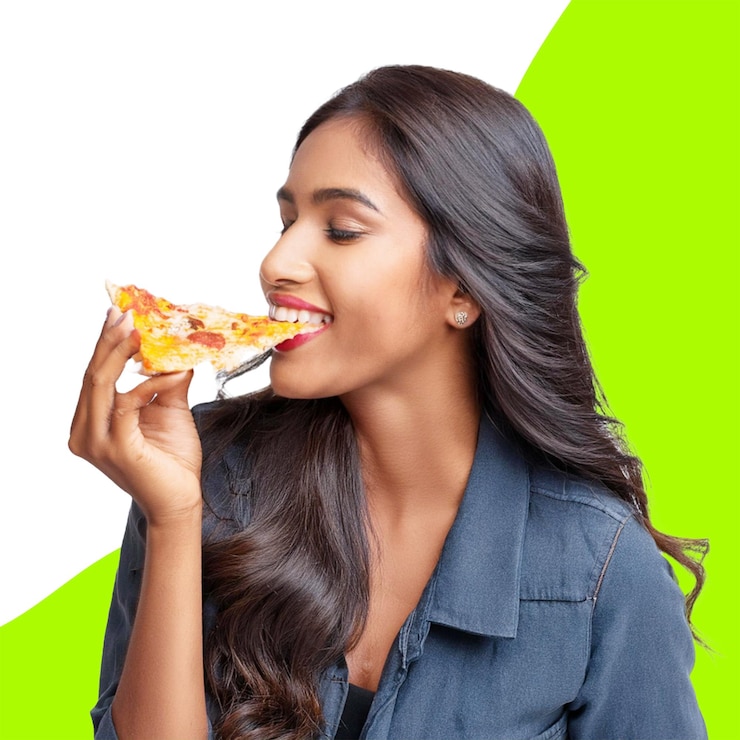 PSD des jeunes femmes mangeant une tranche de pizza sur un fond transparent