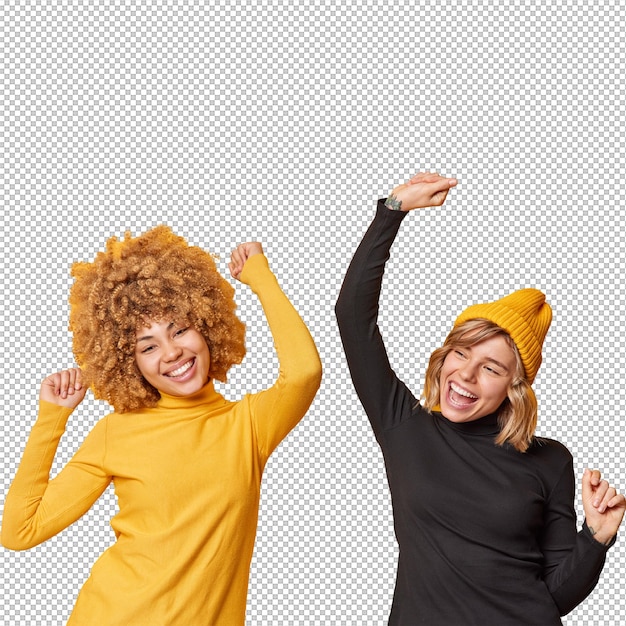 Les jeunes femmes positives et joyeuses s'amusent et dansent sans se soucier, secouent les bras, vêtus de cols rouges décontractés, ont des expressions joyeuses isolées sur un fond jaune.