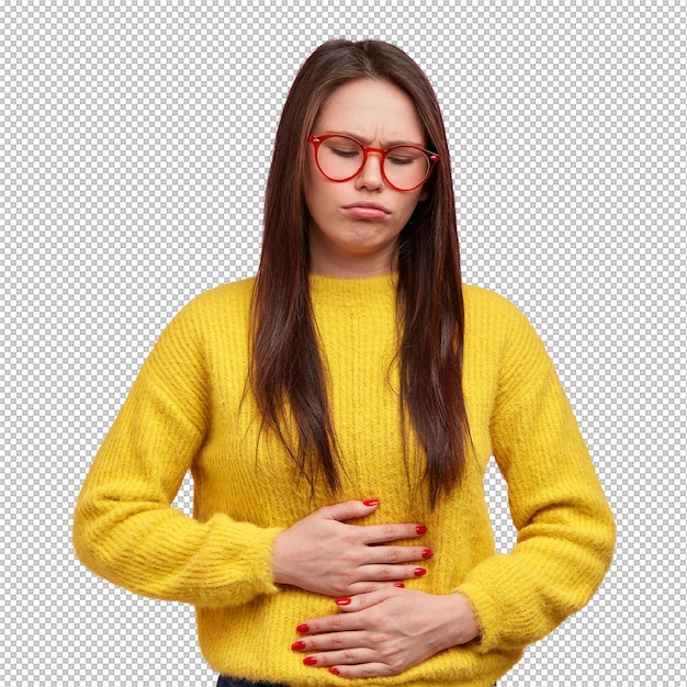 Une jolie femme appuie ses mains sur le ventre ressent de la douleur et de l'inconfort a des problèmes de santé et d'alimentation porte un pull jaune pose sur un fond rose