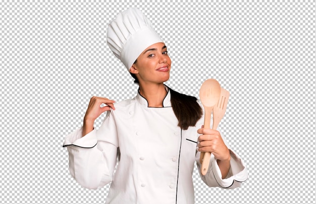 PSD jolie jeune adulte hispanique et femme chef expressive avec des outils de cuisine