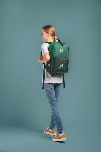 Jovem adolescente carregando uma maquete de mochila