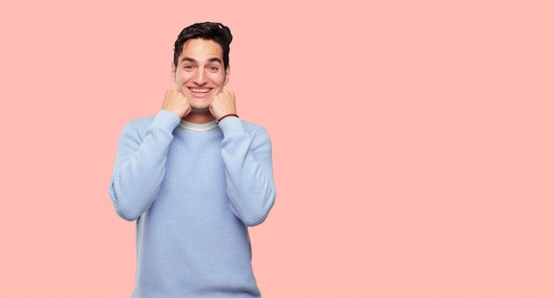 jovem bonito com uma expressão feliz surpresa, olhos bem abertos e largo sorriso